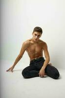 Man sitting on the floor with a naked torso elegant style Studio attractiveness model photo