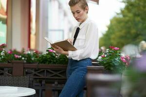 student with a book in his hands outdoors in a summer cafe rest Lifestyle photo