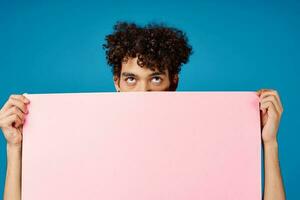 guy with curly hair holding pink Poster mockup Coffee Space photo