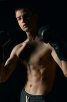 Boxer en negro guantes en un oscuro antecedentes inflado torso carrocero foto