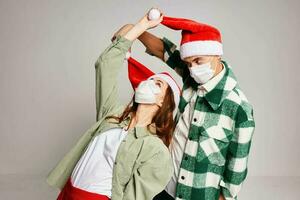 young couple face mask santa hats fun holiday christmas eve photo