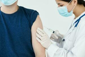 beautiful woman doctor in medical mask giving an injection to a patient vaccination photo