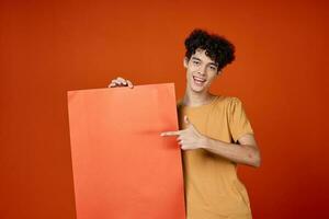 man with curly hair holding a poster in hands Copy Space cropped view photo