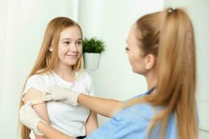 female doctor next to girl vaccination health treatment photo