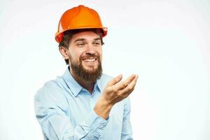 un hombre en un trabajando uniforme naranja difícil sombrero gestos con su manos emociones construcción ingeniero profesional foto