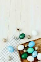 colorful eggs on checkered napkin and wooden background top view Easter tradition photo