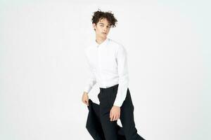 young man with curly hair and in a classic suit holds a jacket in his hand fashion style photography studio model photo