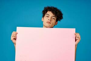 guy with curly hair holding pink Poster mockup photo