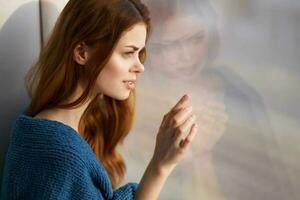 mujer sentado cerca el ventana con un azul tartán Mañana foto