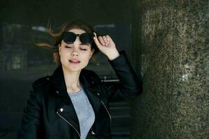 Fashionable woman walking down the street near the building in sunglasses photo