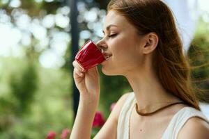 cheerful woman drinking coffee outdoors Happy female relaxing photo