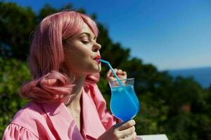 attractive woman with pink hair summer cocktail refreshing drink Relaxation concept photo