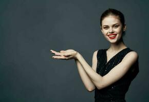 Woman shows emotions with hands to the sides on gray background Copy Space photo