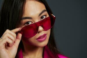 Brunette in pink dress red glasses fashion makeup glamor isolated background photo