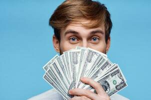 man holding money close-up wealth success blue background photo