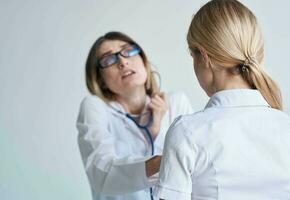 professional woman doctor in medical gown and glasses blue stethoscope patient photo