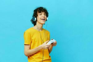 Rizado chico en auriculares obras de teatro juegos gamepad estilo de vida entretenimiento foto