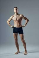 sporty man holding hands on the belt in black shorts inflated body exercise fitness photo