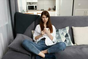 a woman with a phone in her hands a serious look resting at home in an apartment photo