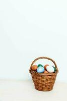 Easter eggs in a wicker basket on a Light background photo