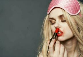 blonde with lipstick smears makeup on her face and eye shadow photo