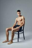 sporty man in black shorts sitting on a chair gymnastics hall rest photo