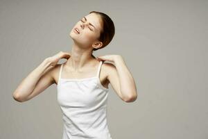 disgruntled woman holding on to the neck health problems joint light background photo