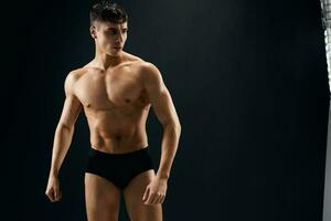 man with naked muscular body in dark panties bodybuilder photo