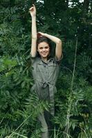 retrato de un mujer elevado su manos arriba y sonrisas arboles foto