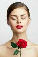 woman with bare shoulders Closed eyes charm rose in hands lipstick photo