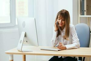 Cheerful adorable blonde businesswoman worker freelancer talking with client registers an order in call in light modern office. Happy employee work on computer online in support service. Copy space photo