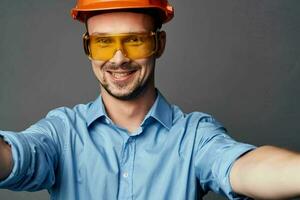 alegre hombre en naranja difícil sombrero construcción profesional herramientas foto