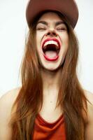Portrait of a woman in a cap Open mouth tongue closed eyes fun red lips photo