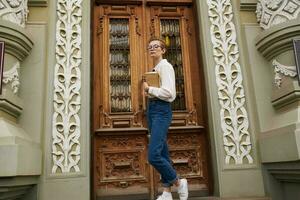 bonito mujer en el calle cerca el edificio descanso educación foto