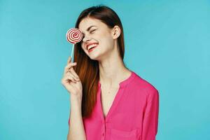 cheerful woman in a pink shirt lollipop in hands emotions luxury photo