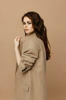 sexy brunette makeup and beige coat side view photo