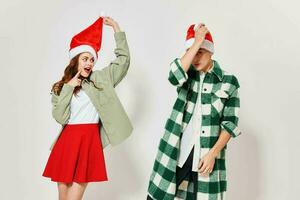 A loving couple in Christmas hats on a light background cropped view photo