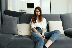 woman sitting on the couch apartment leisure comfort photo