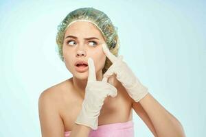 woman in pink towel gloves squeezes pimples dermatology photo