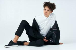 guy sitting on the floor curly hair suit modern style photo