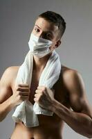 sporty man with a pumped-up torso wearing a medical mask health towel on shoulders photo