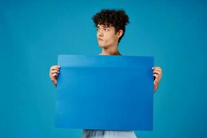 guy in a white t-shirt holding a poster mockup advertising photo