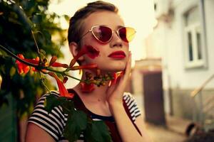 woman in sunglasses on the street near flowers posing lifestyle photo