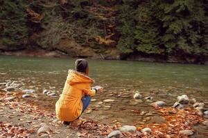 mujer caminando cerca el río caído hojas naturaleza montañas foto