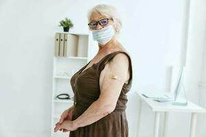 elderly woman in medical mask sitting in hospital vaccine passport photo