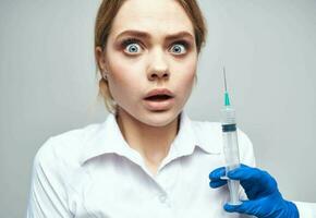 Frightened patient And syringe in hand blue gloves medicine photo