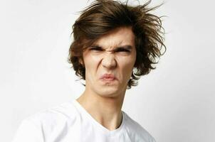 emotional guy in white t-shirt tousled hair teenager close-up photo