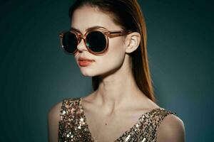 woman wearing sunglasses golden dress studio luxury dark background decoration photo