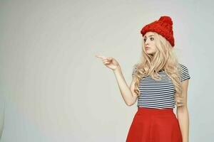 bonito mujer en de moda ropa rojo sombrero ligero antecedentes estilo de vida foto