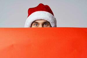 emotional man in a christmas hat with Red mockup poster light background photo